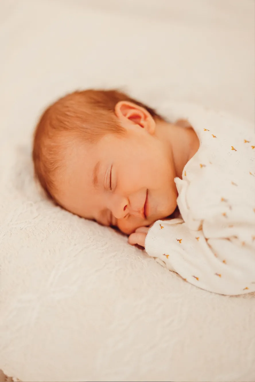 Hell bekleidetes Baby schlafend auf weicher Decke Responsive